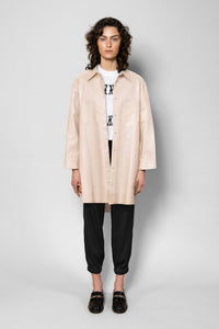 Person wearing a beige trench coat on a white background